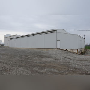 This 42â??x58â?? building is attached to the west end of Building B.  It includes a small office area, concrete floor, (2) 15â??x17â?? sliders, walk-in door, and 220 amp single-phase & 3-phase electric.