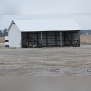 This building is a 26â??x50â??, 3-sided pole shed with 11.5â?? eves and gravel floor.