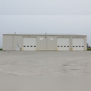 This steel-framed, completely insulated building boasts many custom features making it ideal for multiple purposes.  It includes (3) office areas with built-in work surfaces, air conditioning, and LP gas forced-air heat. (2 offices are 12â??x11â?? & the other is 19â??x11â??.)  The garage/shop area is 75â??x100â?? with concrete floors & approaches, (6) 16â??x16â?? overhead doors with openers, (4) walk-in doors, and loft storage area above offices.  Additional amenities include (2) Reznor LP heaters, Energylogic waste oil furnace, ventilation system with louvered panels, ceiling fans, multiple electrical panels with 220 amp service, several outdoor electrical outlets with pigtail cords to plug in tractors, semis, etc., and a 10 HP 2-stage NAPA air compressor.