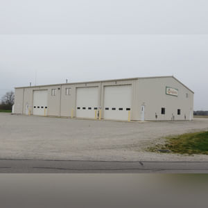 This steel-framed, completely insulated building boasts many custom features making it ideal for multiple purposes.  It includes (3) office areas with built-in work surfaces, air conditioning, and LP gas forced-air heat. (2 offices are 12â??x11â?? & the other is 19â??x11â??.)  The garage/shop area is 75â??x100â?? with concrete floors & approaches, (6) 16â??x16â?? overhead doors with openers, (4) walk-in doors, and loft storage area above offices.  Additional amenities include (2) Reznor LP heaters, Energylogic waste oil furnace, ventilation system with louvered panels, ceiling fans, multiple electrical panels with 220 amp service, several outdoor electrical outlets with pigtail cords to plug in tractors, semis, etc., and a 10 HP 2-stage NAPA air compressor.