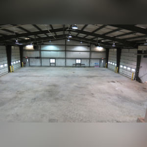 This steel-framed, completely insulated building boasts many custom features making it ideal for multiple purposes.  It includes (3) office areas with built-in work surfaces, air conditioning, and LP gas forced-air heat. (2 offices are 12â??x11â?? & the other is 19â??x11â??.)  The garage/shop area is 75â??x100â?? with concrete floors & approaches, (6) 16â??x16â?? overhead doors with openers, (4) walk-in doors, and loft storage area above offices.  Additional amenities include (2) Reznor LP heaters, Energylogic waste oil furnace, ventilation system with louvered panels, ceiling fans, multiple electrical panels with 220 amp service, several outdoor electrical outlets with pigtail cords to plug in tractors, semis, etc., and a 10 HP 2-stage NAPA air compressor.