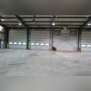 This steel-framed, completely insulated building boasts many custom features making it ideal for multiple purposes.  It includes (3) office areas with built-in work surfaces, air conditioning, and LP gas forced-air heat. (2 offices are 12â??x11â?? & the other is 19â??x11â??.)  The garage/shop area is 75â??x100â?? with concrete floors & approaches, (6) 16â??x16â?? overhead doors with openers, (4) walk-in doors, and loft storage area above offices.  Additional amenities include (2) Reznor LP heaters, Energylogic waste oil furnace, ventilation system with louvered panels, ceiling fans, multiple electrical panels with 220 amp service, several outdoor electrical outlets with pigtail cords to plug in tractors, semis, etc., and a 10 HP 2-stage NAPA air compressor.