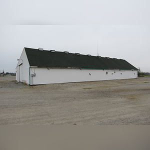 This drive-thru storage building is 60â??x105â?? with concrete floors, a front office area, a newer shingled roof, and 480 amp service.  There are (8) 11â??x32â?? individual storage bays, (2) end-sliders, and (2) walk-in doors.